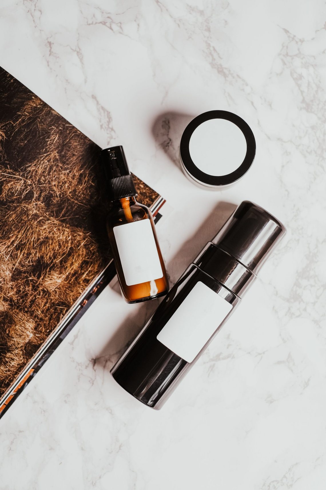 A compact selection of skincare products on a pale marble surface
