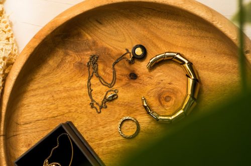 Gold and silver jewelry arranged together on a neutral surface